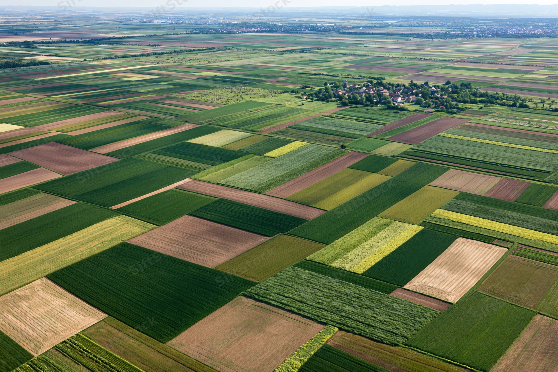 Aerial view of patchwork agricultural fields stretching to the horizon