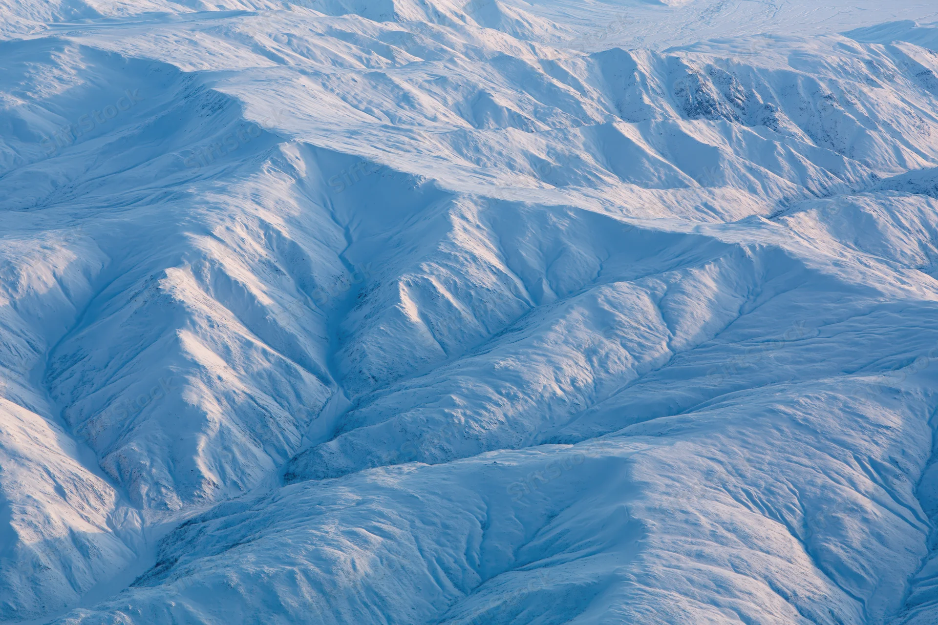 Aerial view of snow-covered mountain range from directly above