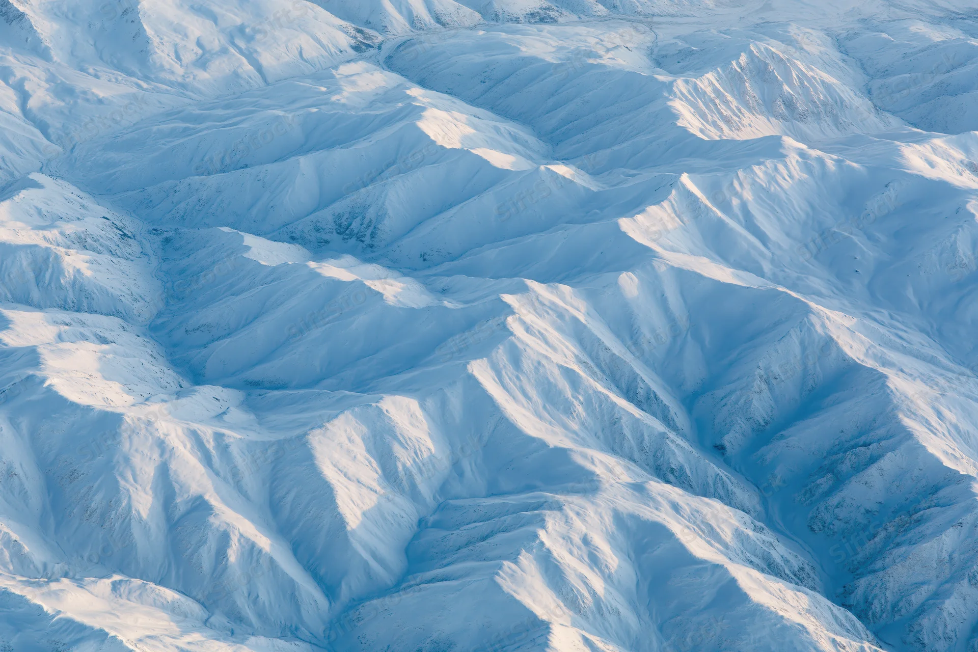 Aerial view of snow-covered mountain range from directly above