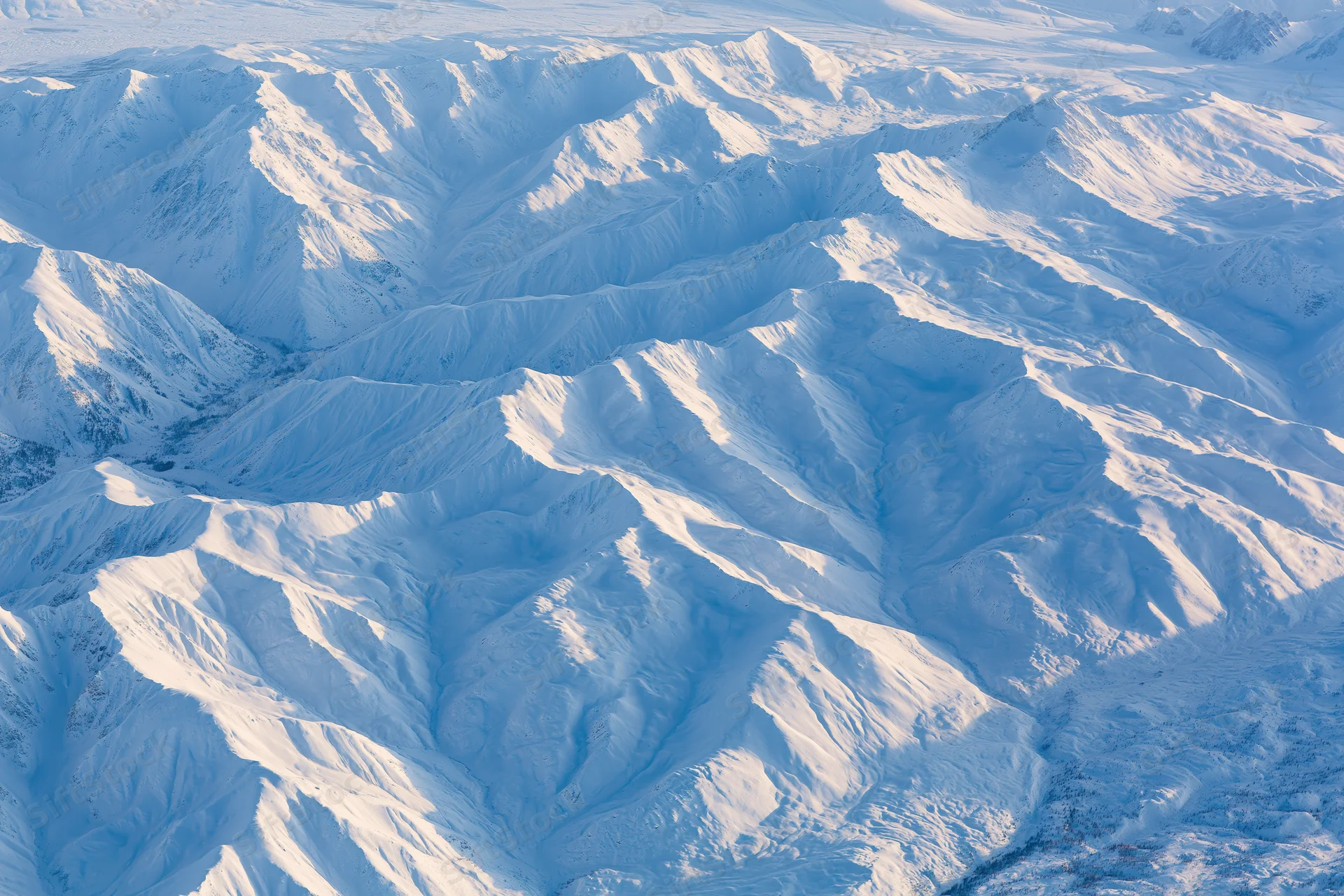 Aerial view of snow-covered mountain range from above