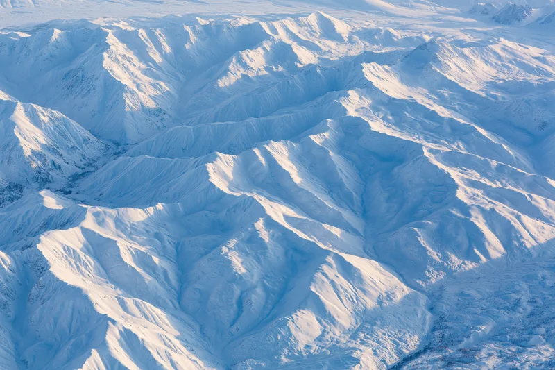 Aerial view of snow-covered mountain range from above
