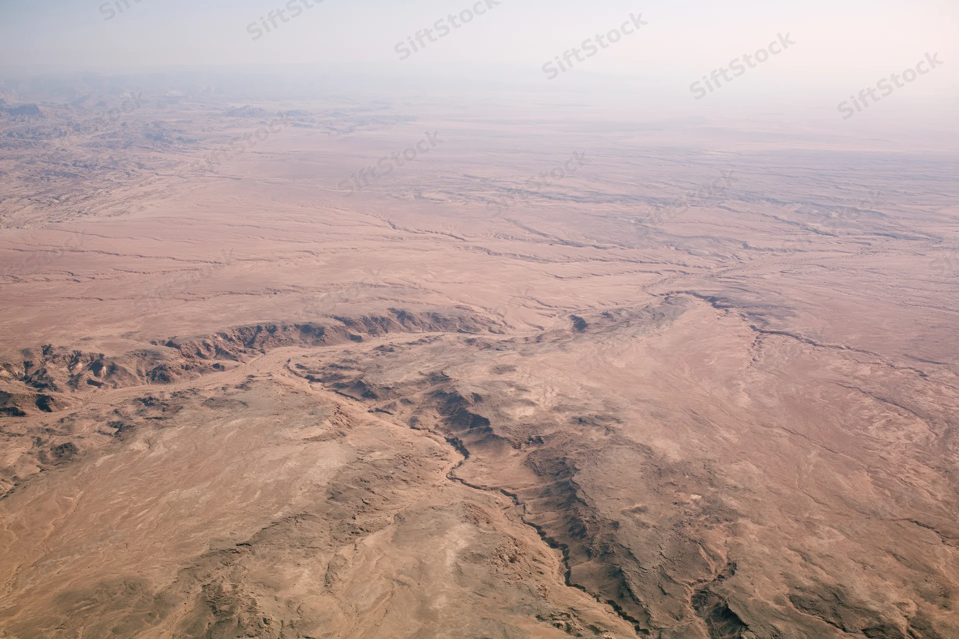 Aerial view of vast arid desert landscape from high altitude