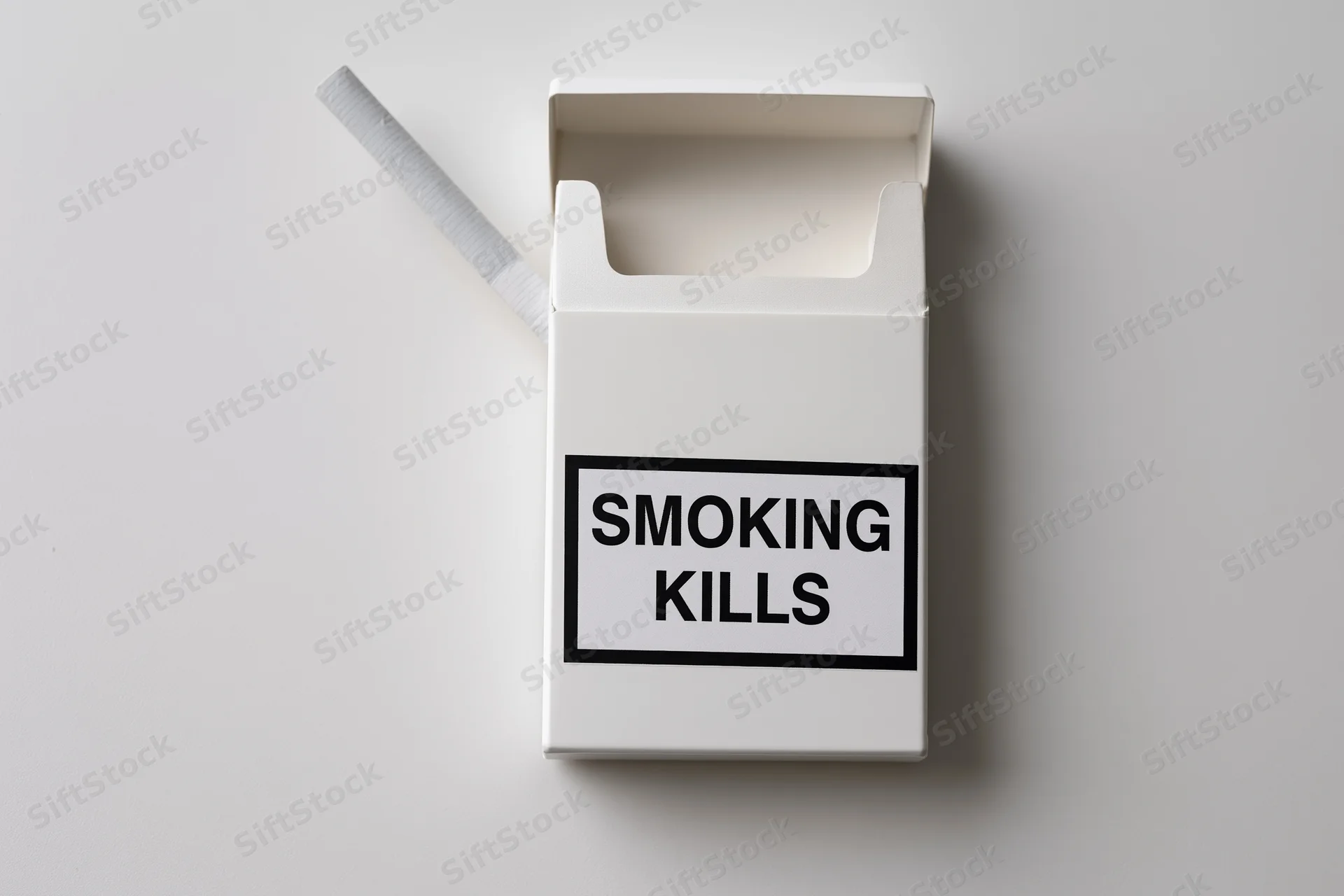 Open white cigarette pack with one cigarette sticking out and smoking kills warning label on plain surface