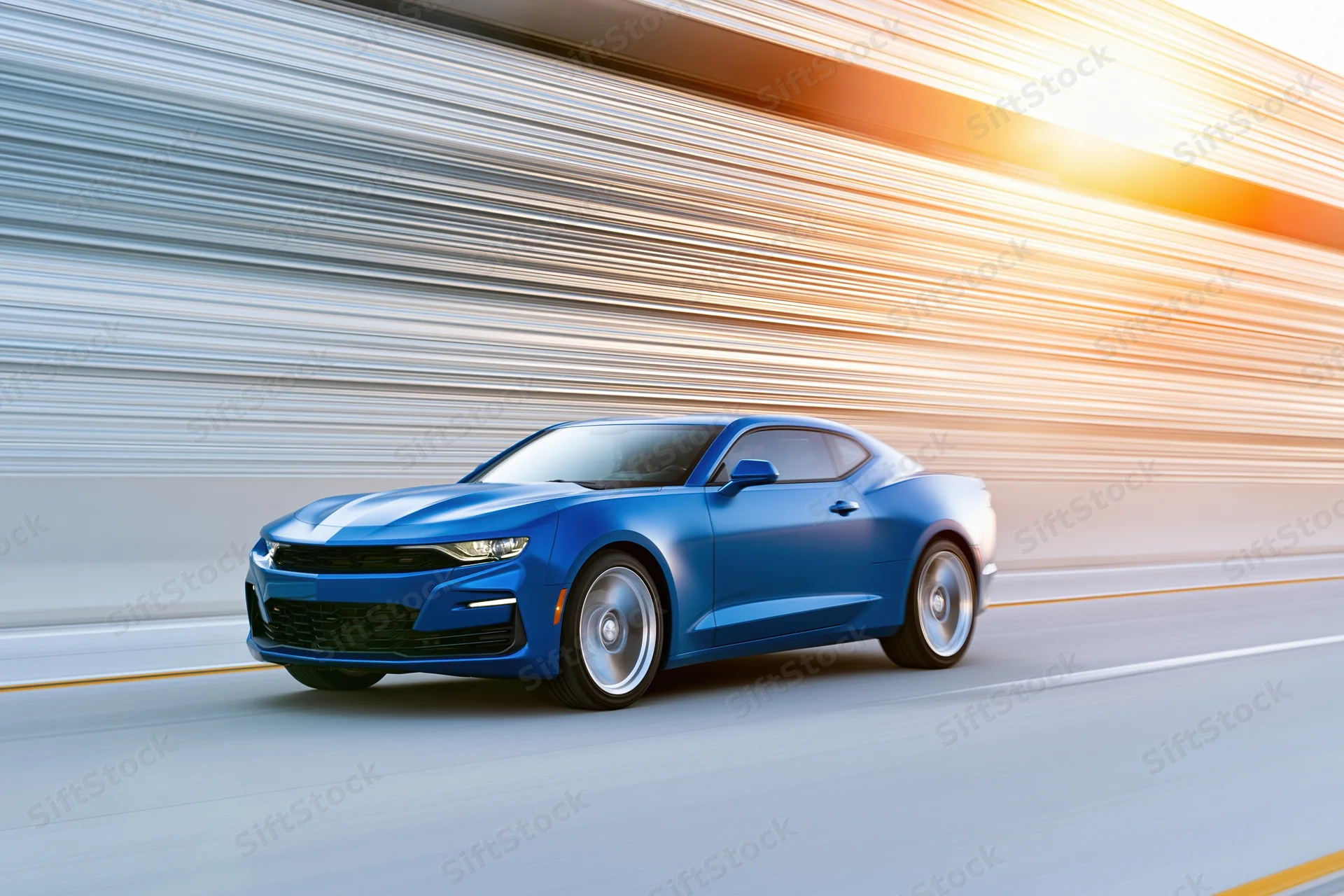 Blue chevrolet camaro muscle car driving at speed on a highway with motion blur