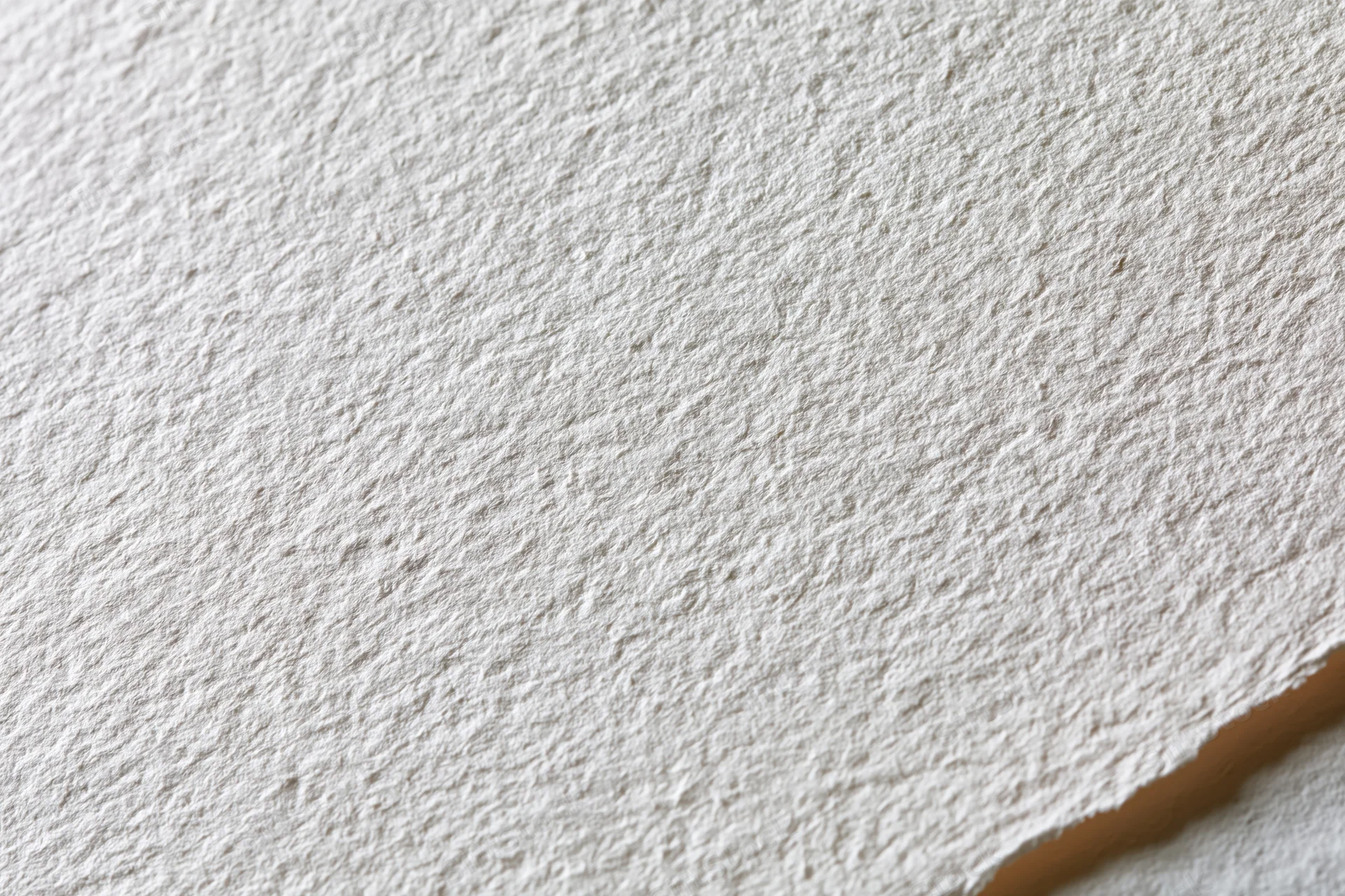 Close-up of blank white watercolor paper with textured surface and torn edge