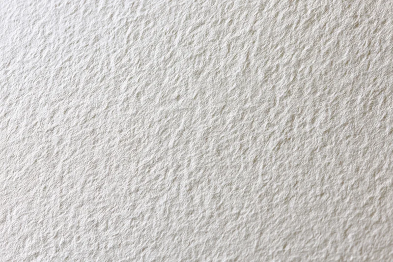 Close-up of blank white watercolor paper with textured surface filling the frame