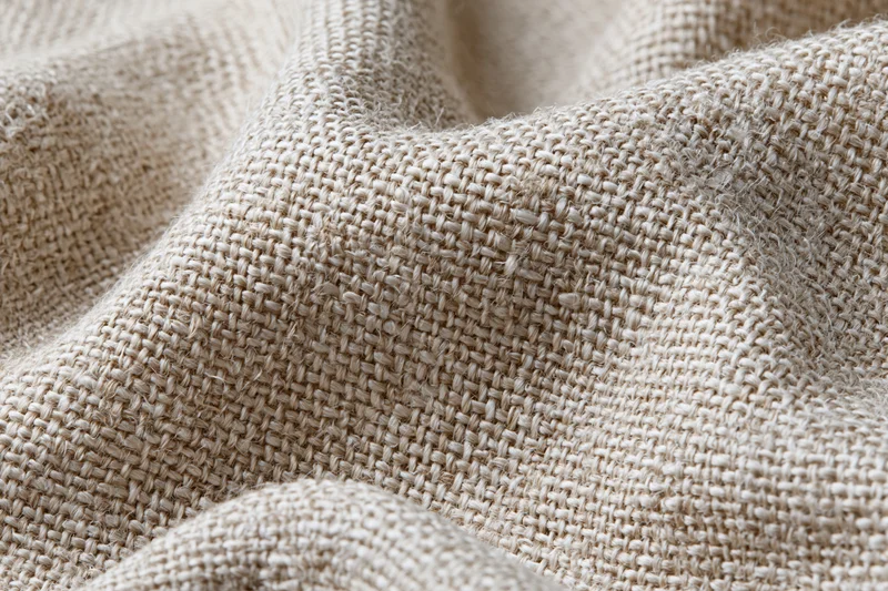 Close-up of natural linen fabric with visible weave and texture filling the frame