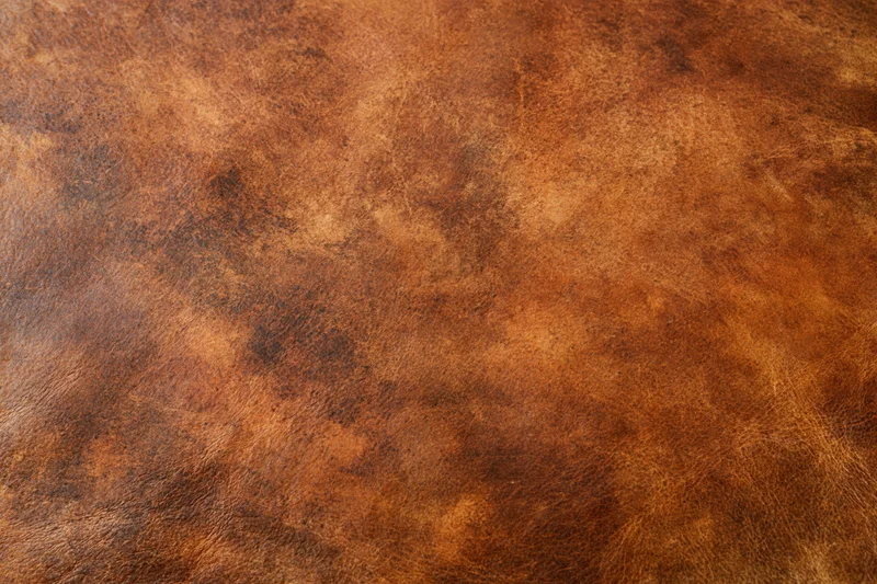 Close-up of aged worn leather surface with visible grain and texture