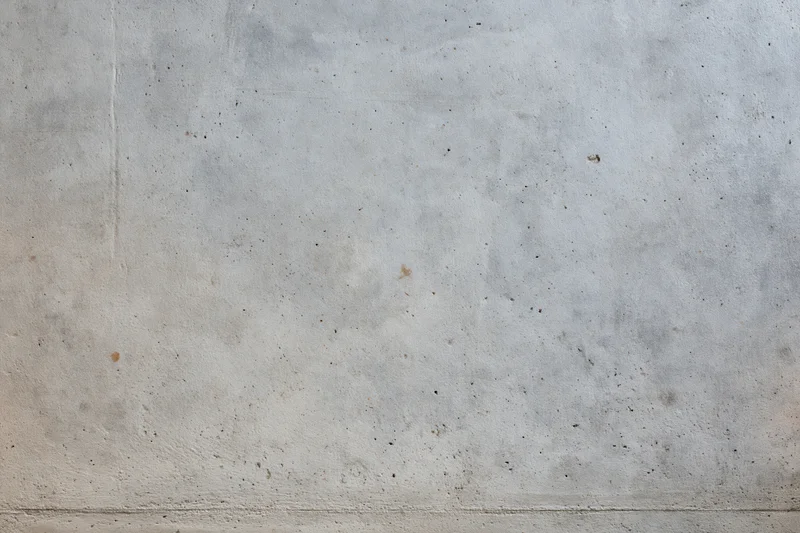 Close-up of a bare concrete wall with rough texture and subtle discoloration