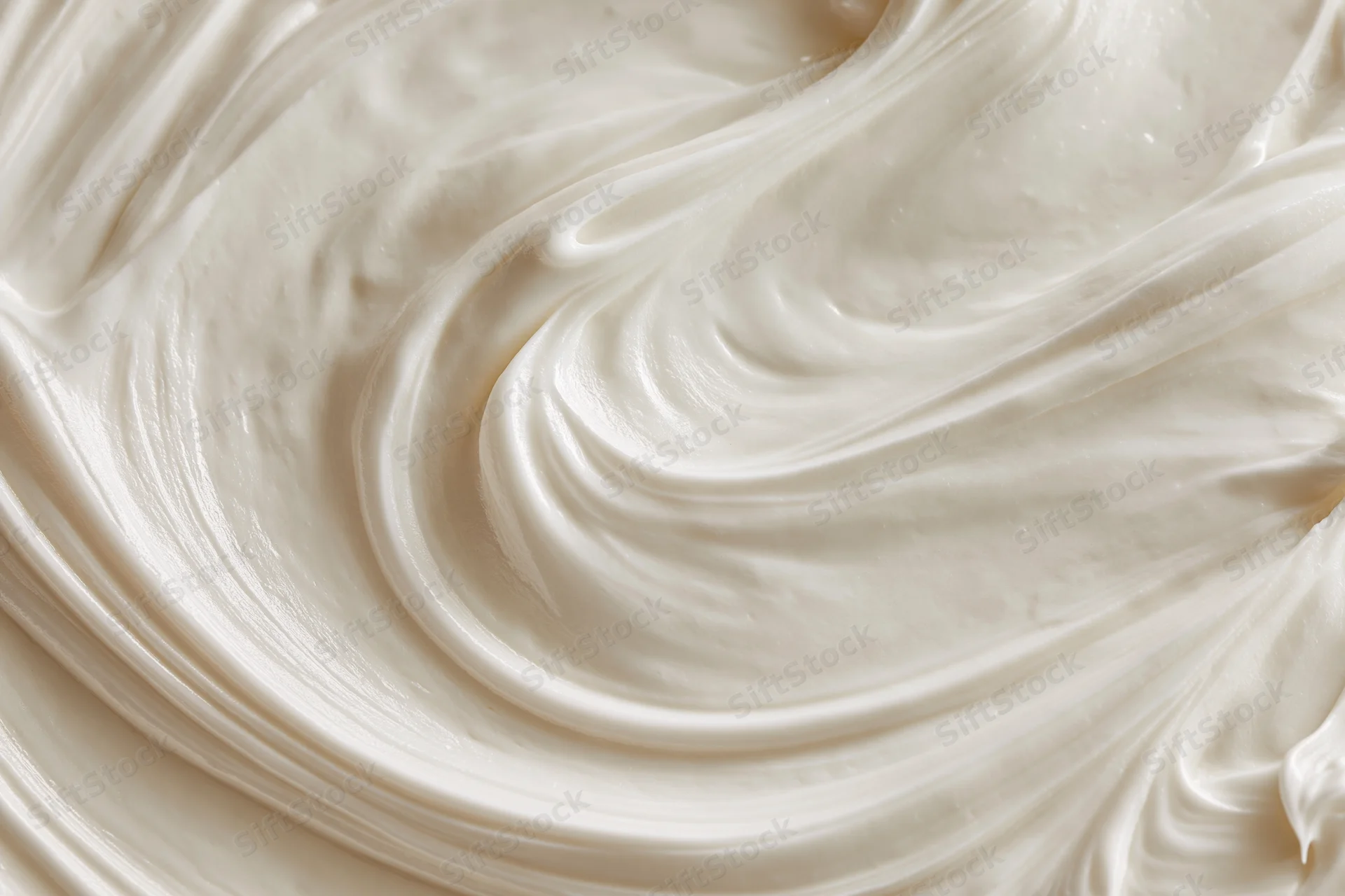 Close-up of smooth white cream with swirling texture filling the frame