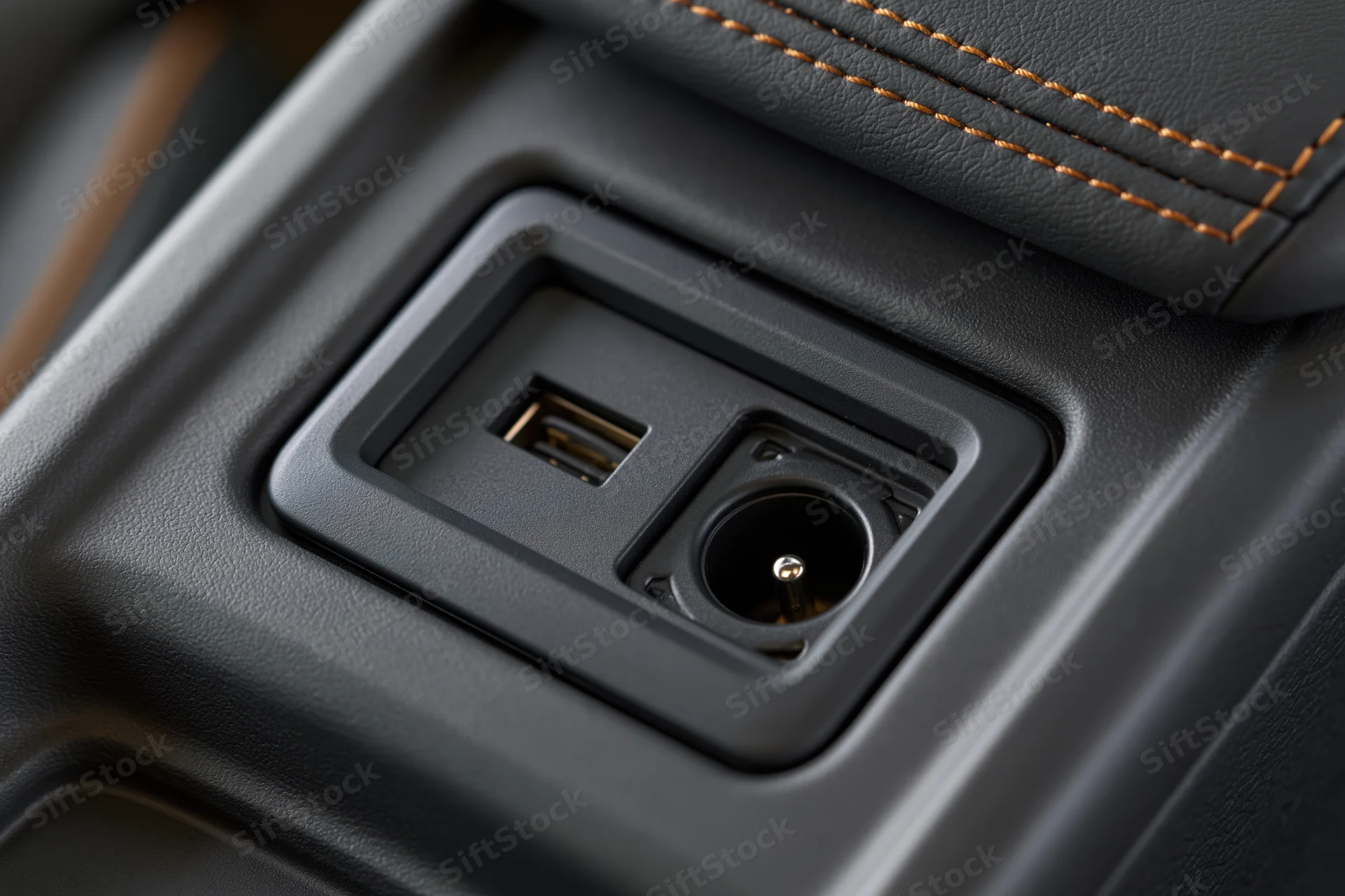 Close-up of car center console storage compartment with usb port and power socket