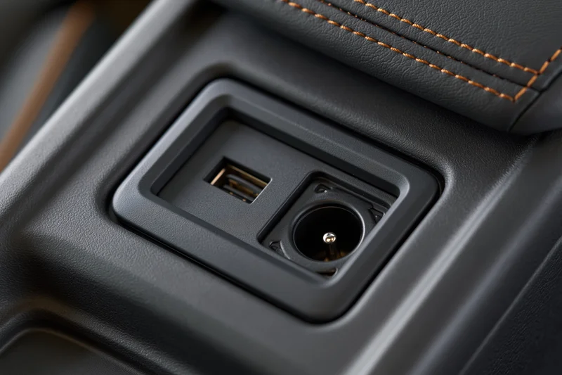 Close-up of car center console storage compartment with usb port and power socket