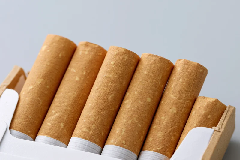 Close-up of cigarettes in an open pack on a plain background