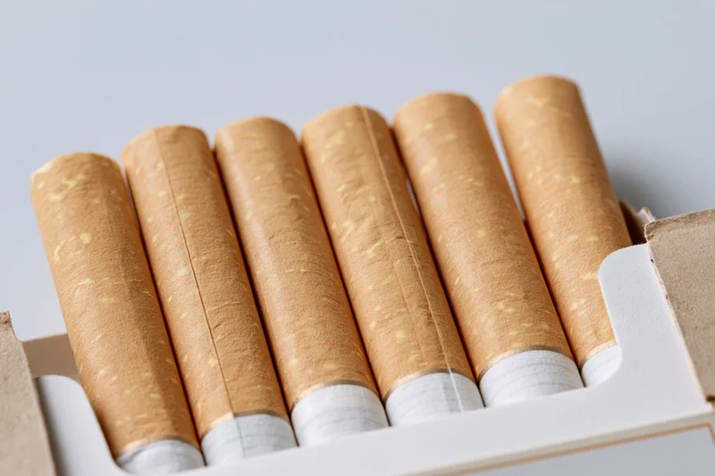 Close-up of cigarettes in an open pack showing filter tips and brown paper wrapping