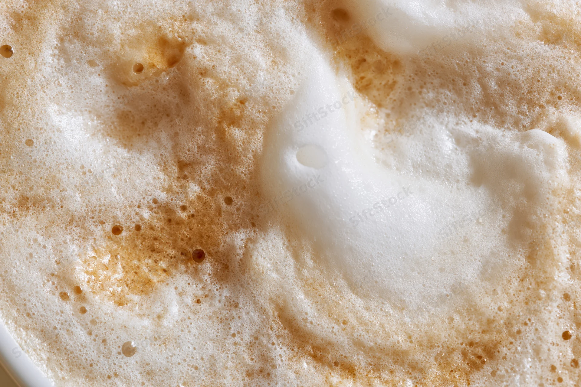 Close-up overhead view of steamed milk foam surface in a coffee drink
