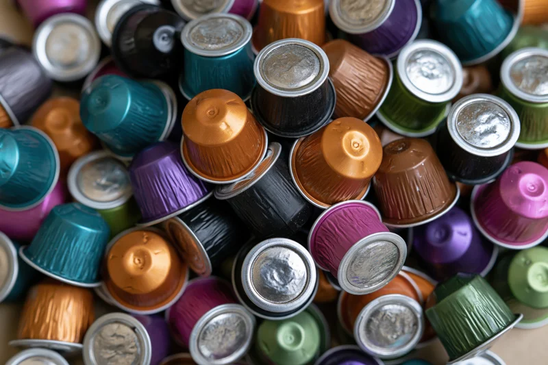 Used coffee capsules piled together in a colorful heap