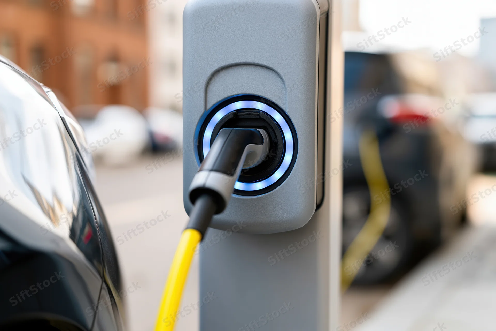 Electric vehicle charging connector plugged into public station on city street