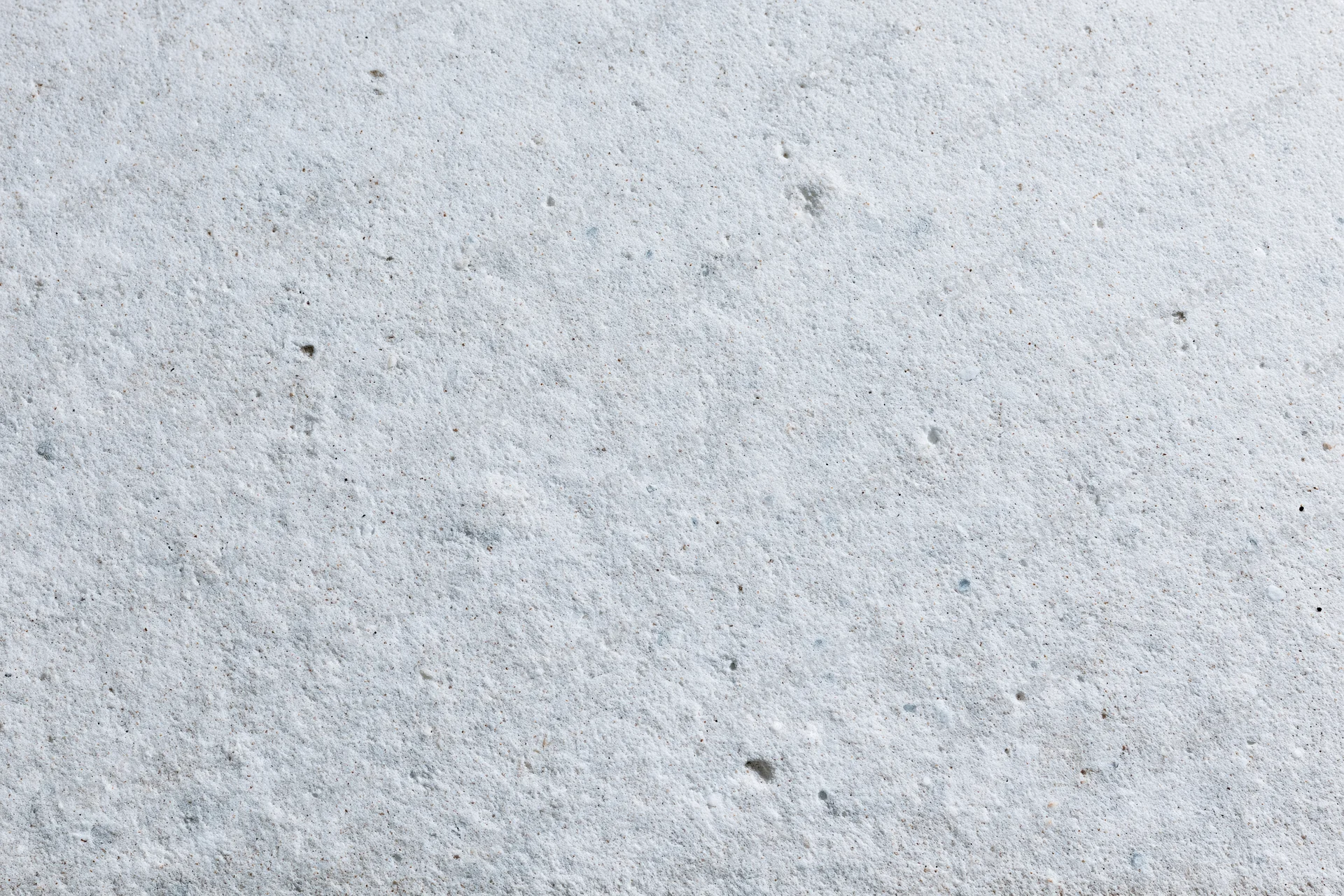 Close-up of a smooth gray concrete surface with small speckles and pores