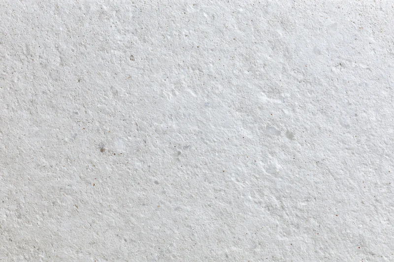 Close-up of a white concrete surface with rough texture and speckled pattern