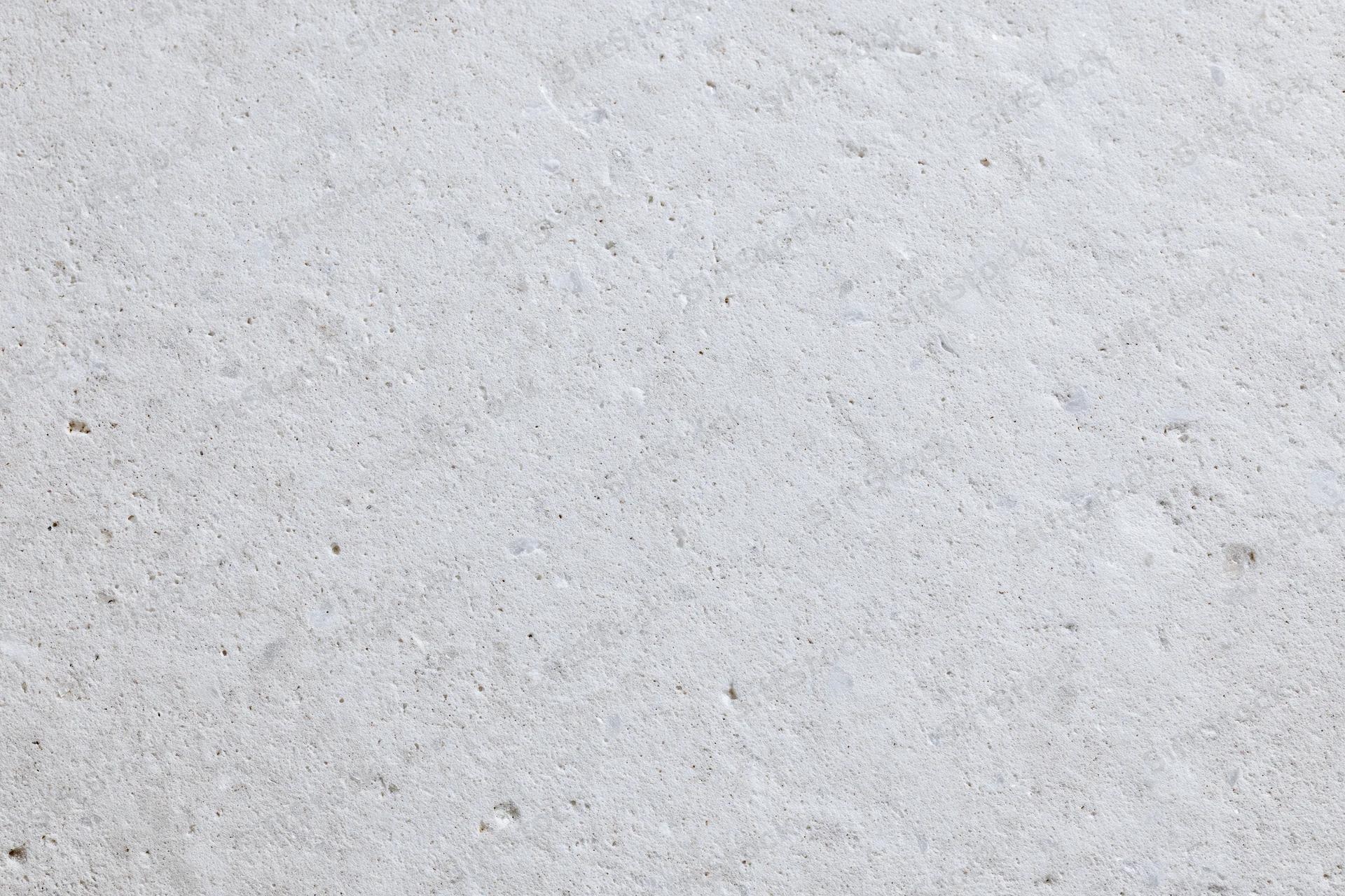 Close-up of a smooth concrete or limestone surface with natural texture and speckled finish