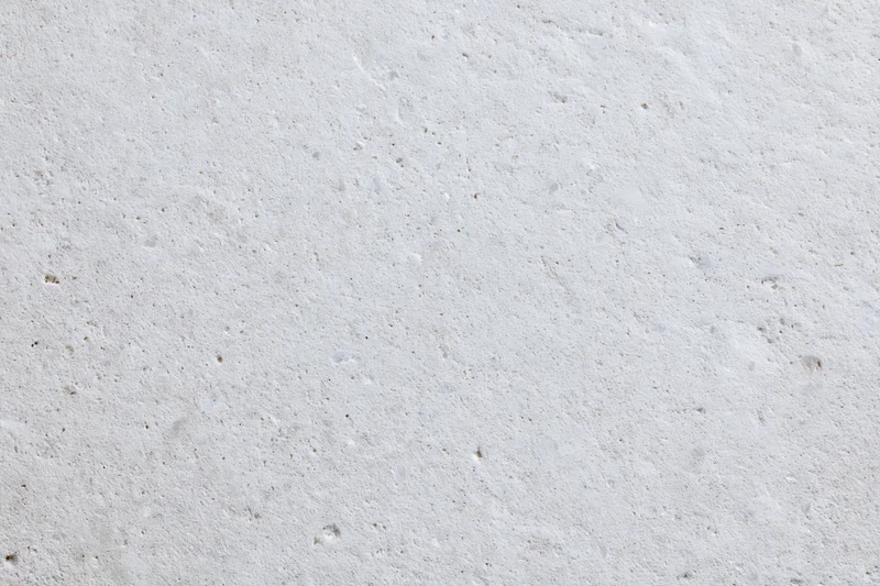 Close-up of a smooth concrete or limestone surface with natural texture and speckled finish