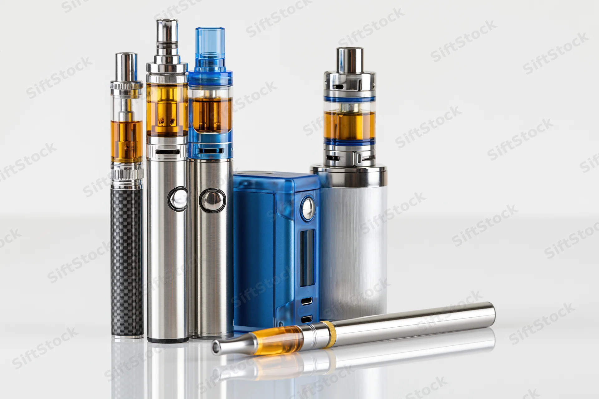 Multiple vaping devices arranged on a reflective white surface