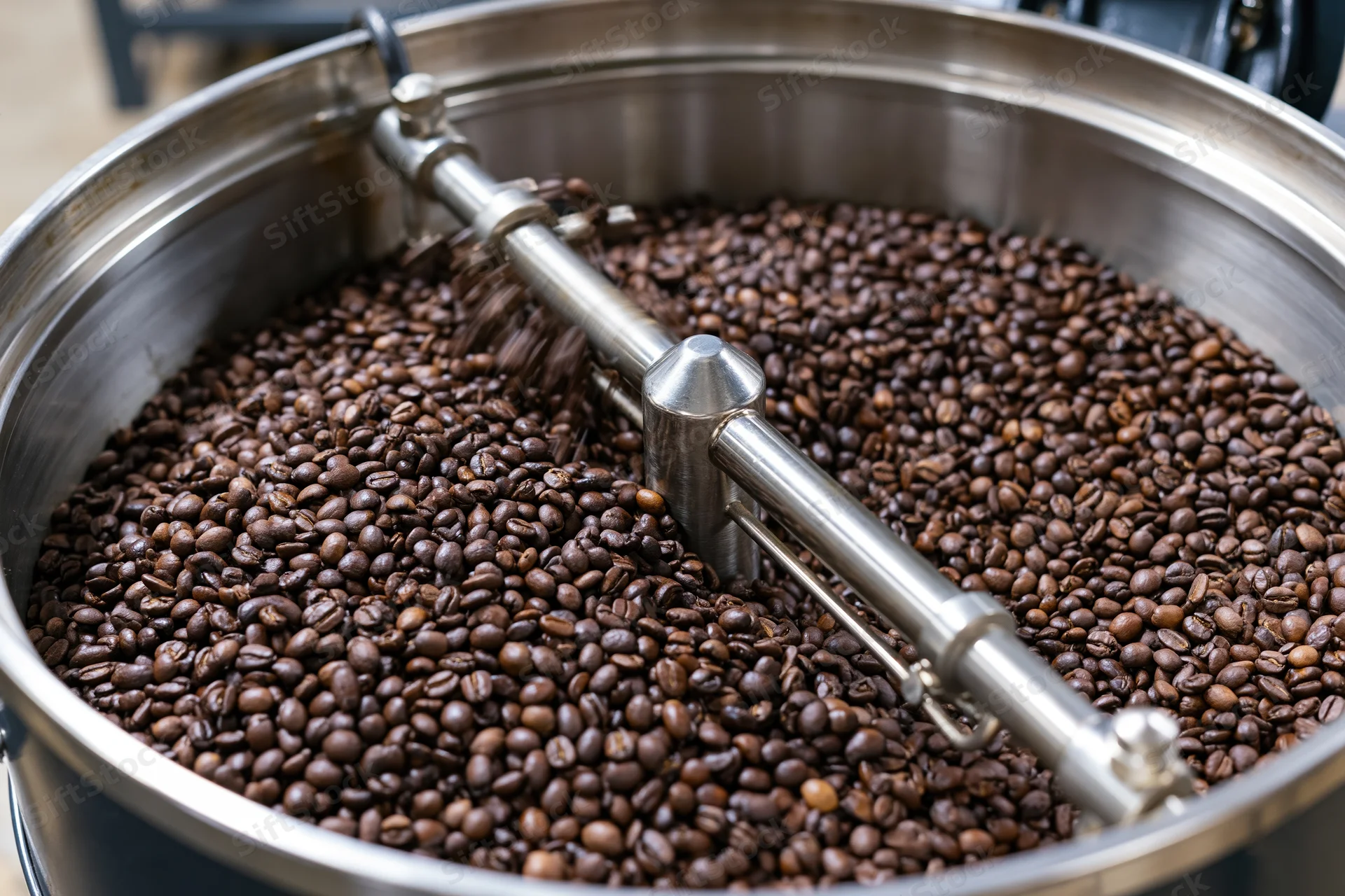 Coffee beans cooling in a stainless steel roasting drum inside a roastery