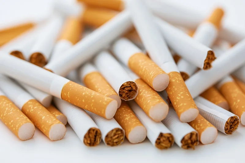 Loose cigarettes scattered in a pile on a white surface