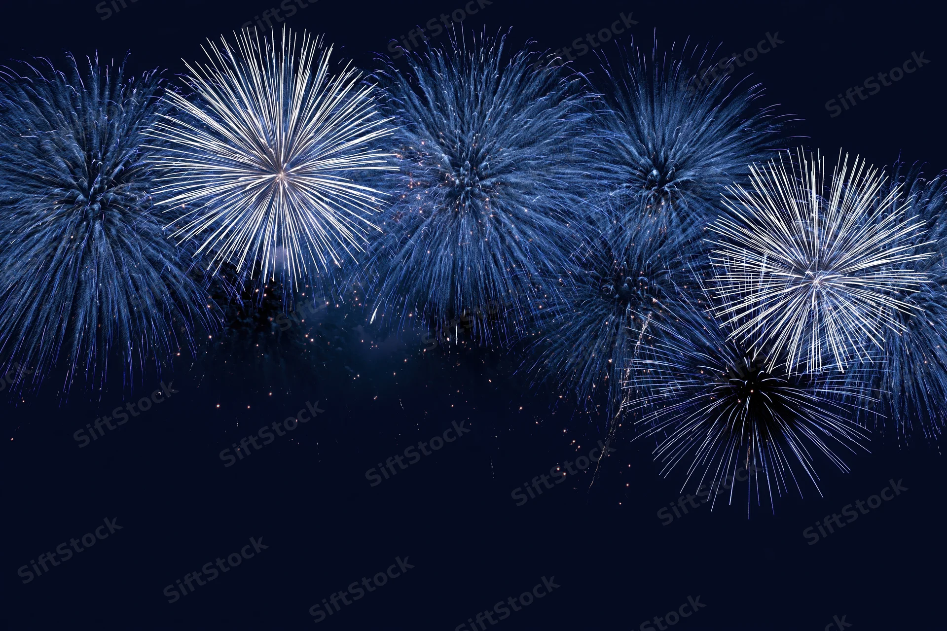 Blue and white fireworks bursting across the night sky in a festive display