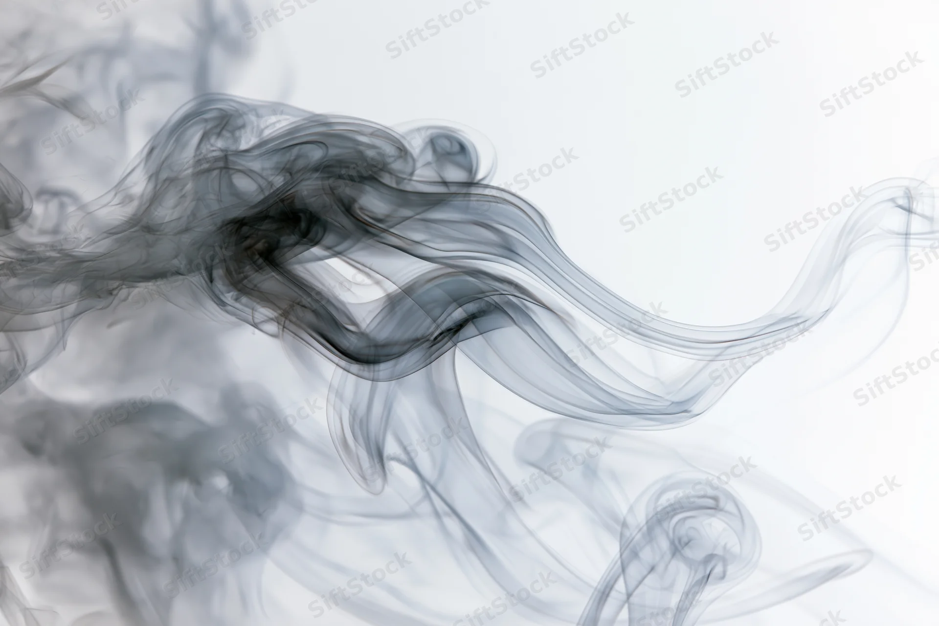 Dark smoke wisps curling and drifting upward against a white background