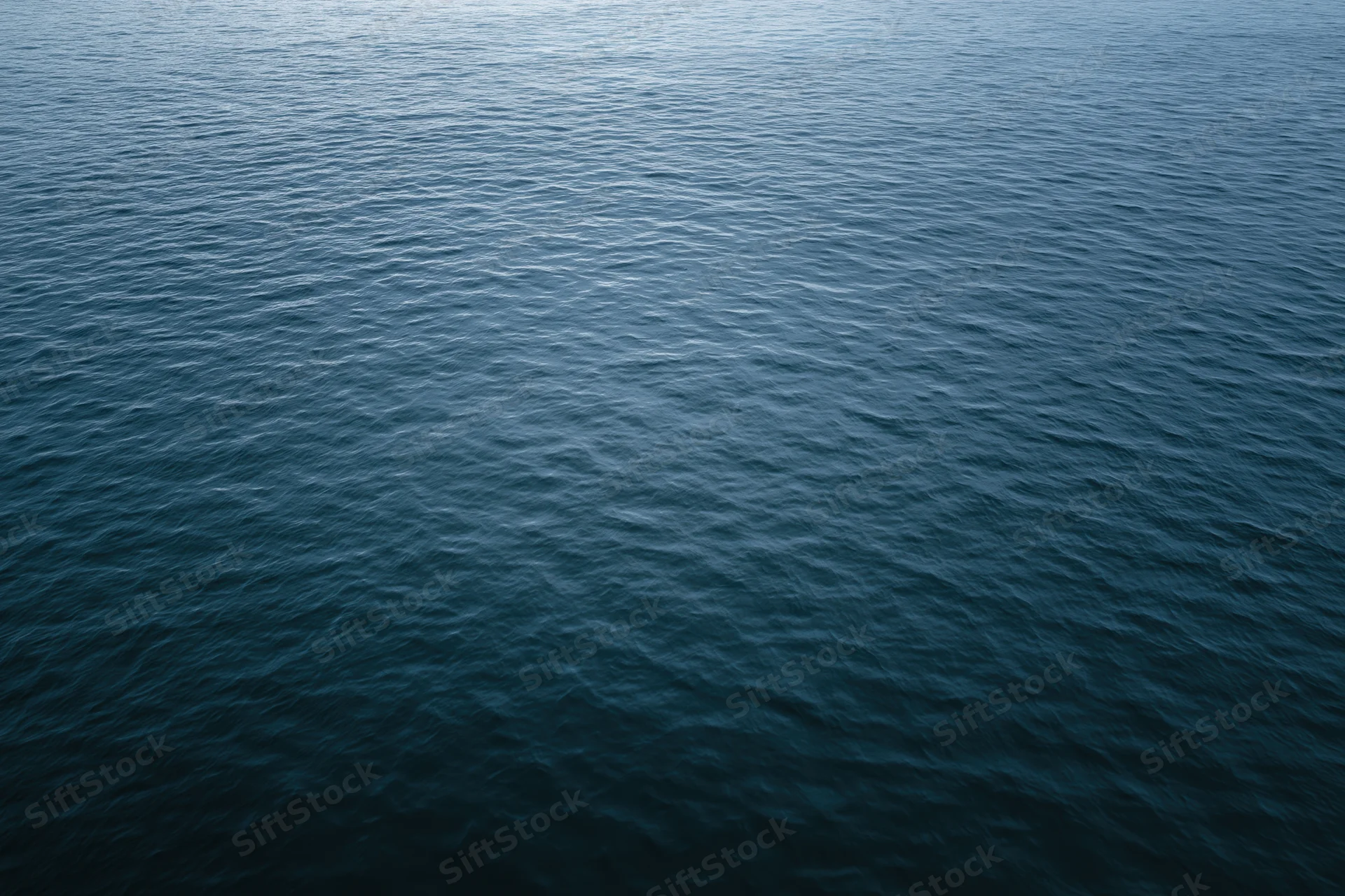 Aerial view of open ocean surface with ripples and waves, no horizon visible