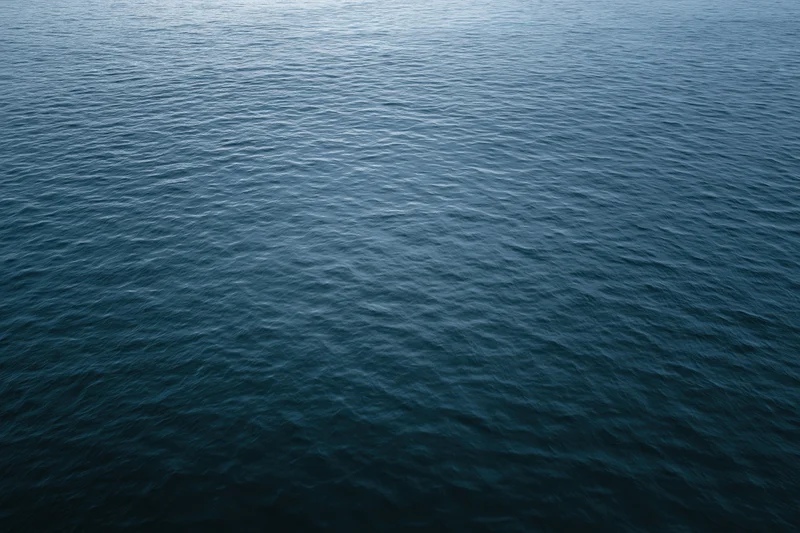 Aerial view of open ocean surface with ripples and waves, no horizon visible