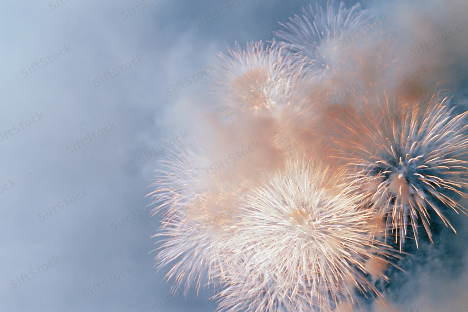 Fireworks bursting in the night sky with soft glow and smoke trails