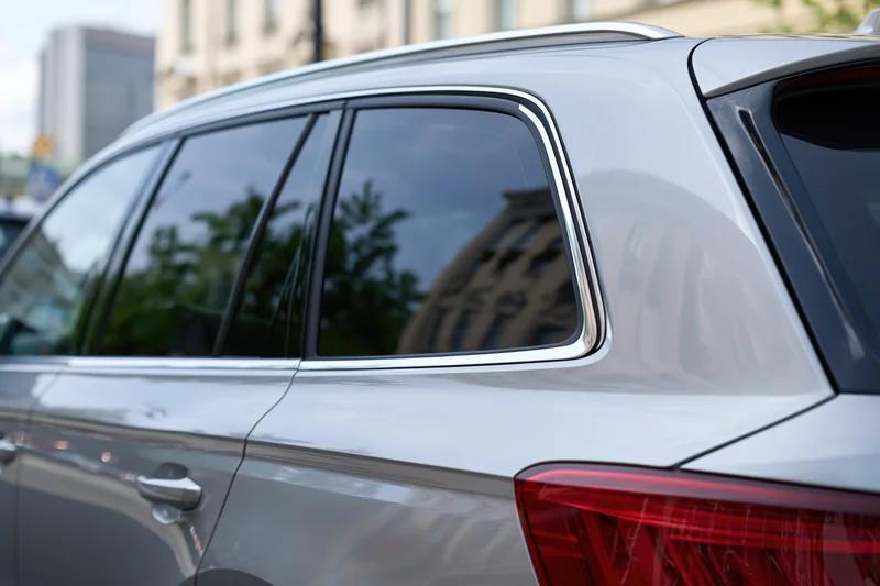 Silver suv rear window and taillight parked on city street