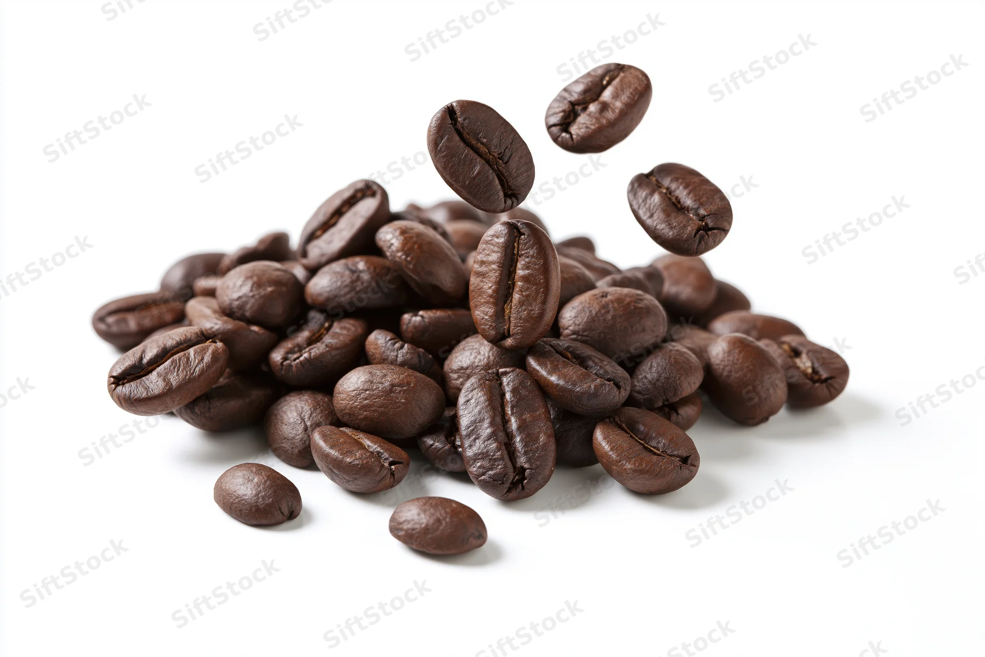 Roasted coffee beans falling and landing onto a small pile on white background