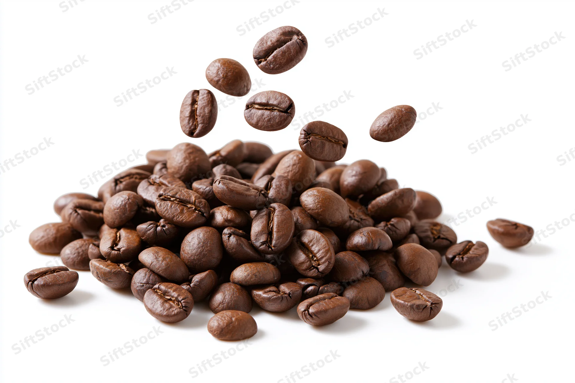 Roasted coffee beans falling and landing onto a small pile on white background