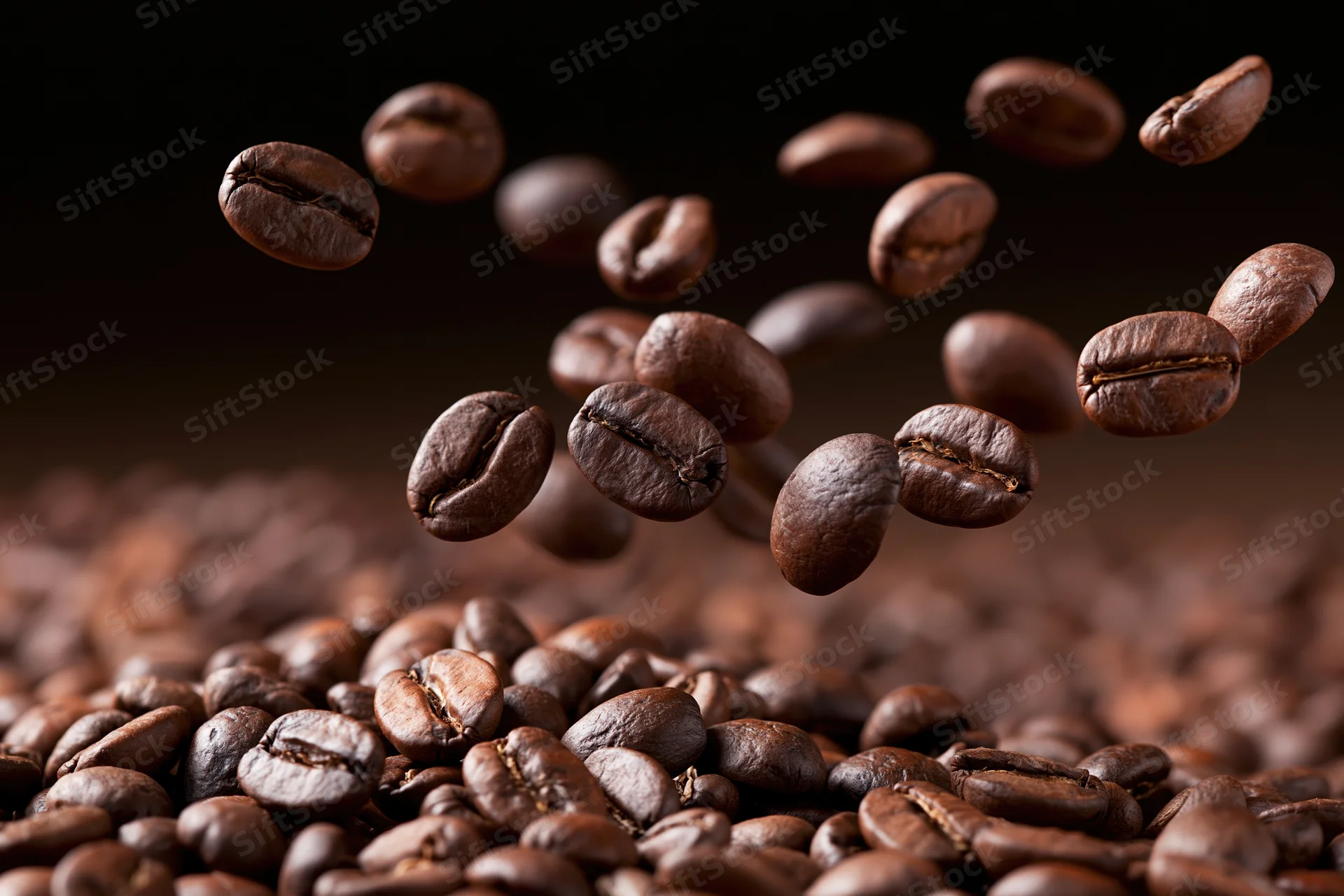 Roasted coffee beans falling and tumbling onto a pile in close-up view