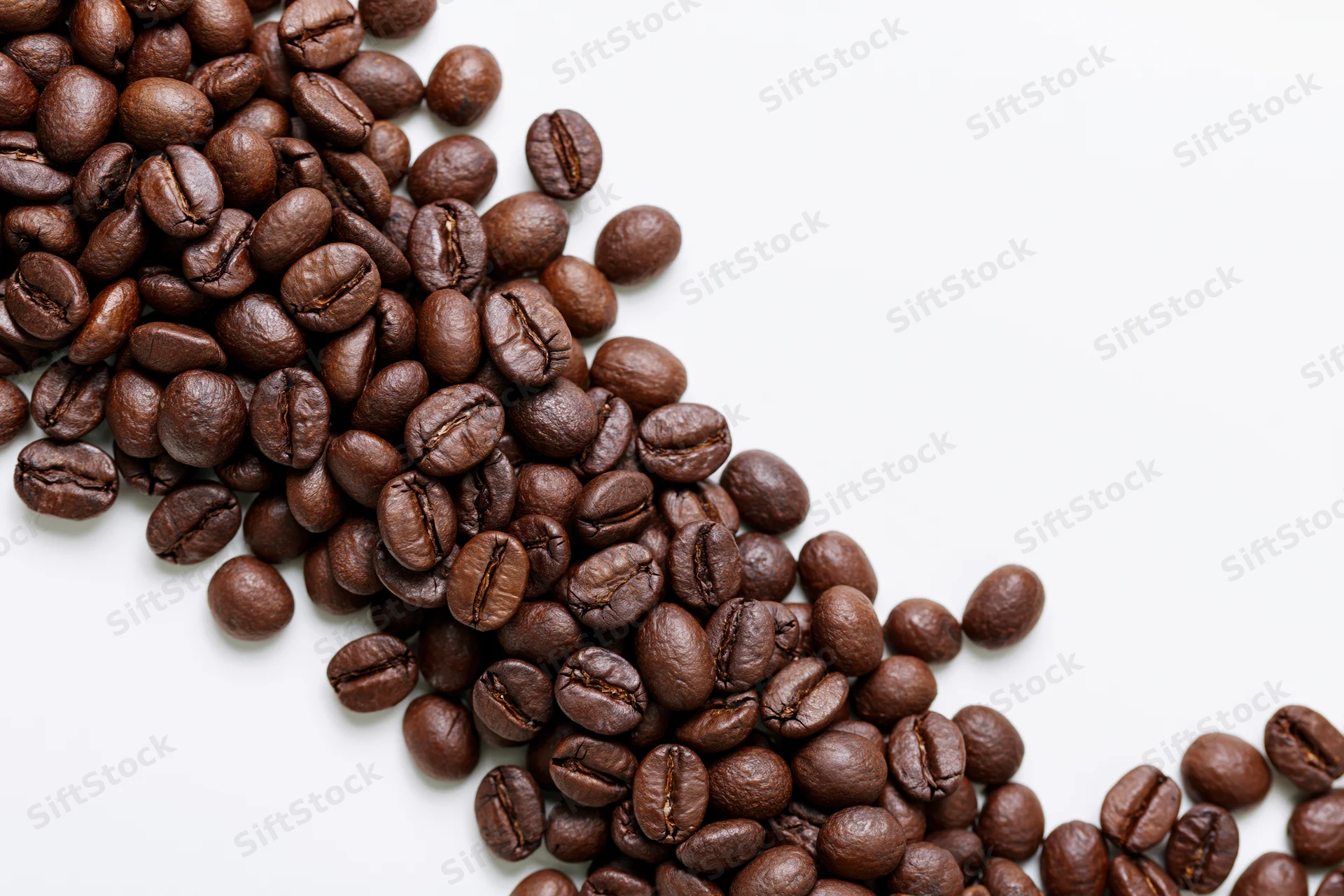 Roasted coffee beans scattered loosely along the bottom-left on white background