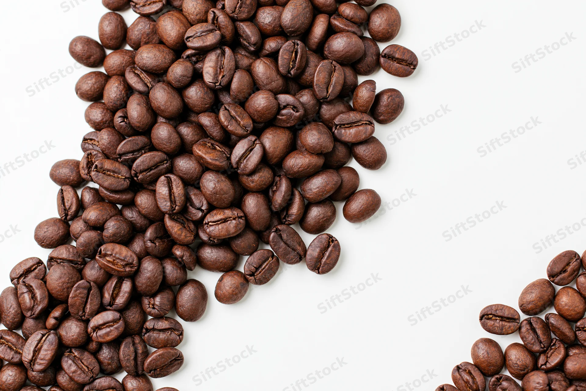 Roasted coffee beans scattered loosely along the bottom-left on white background
