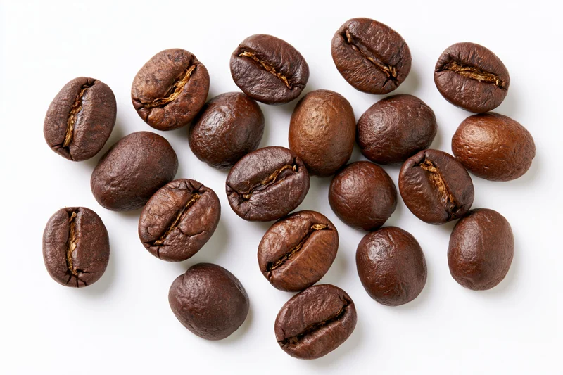 Roasted coffee beans scattered on a white background