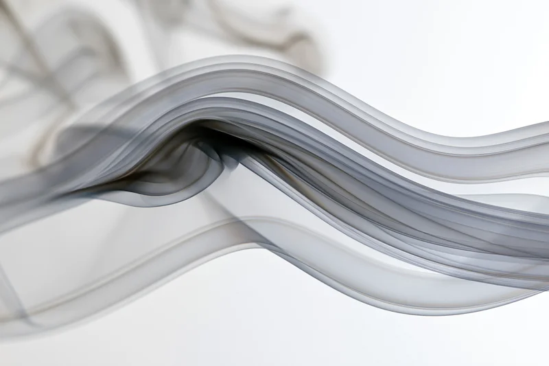 Dark smoke wisps flowing in slow motion against a white background