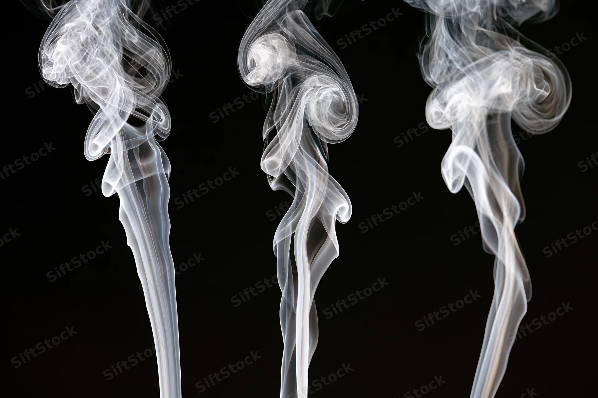 Three white smoke wisps rising and curling upward against a black background