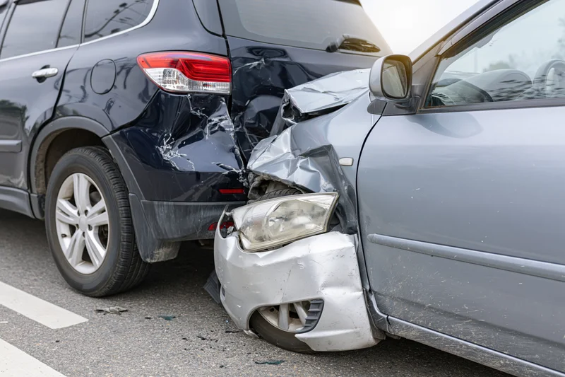 Two damaged cars in rear-end collision on road