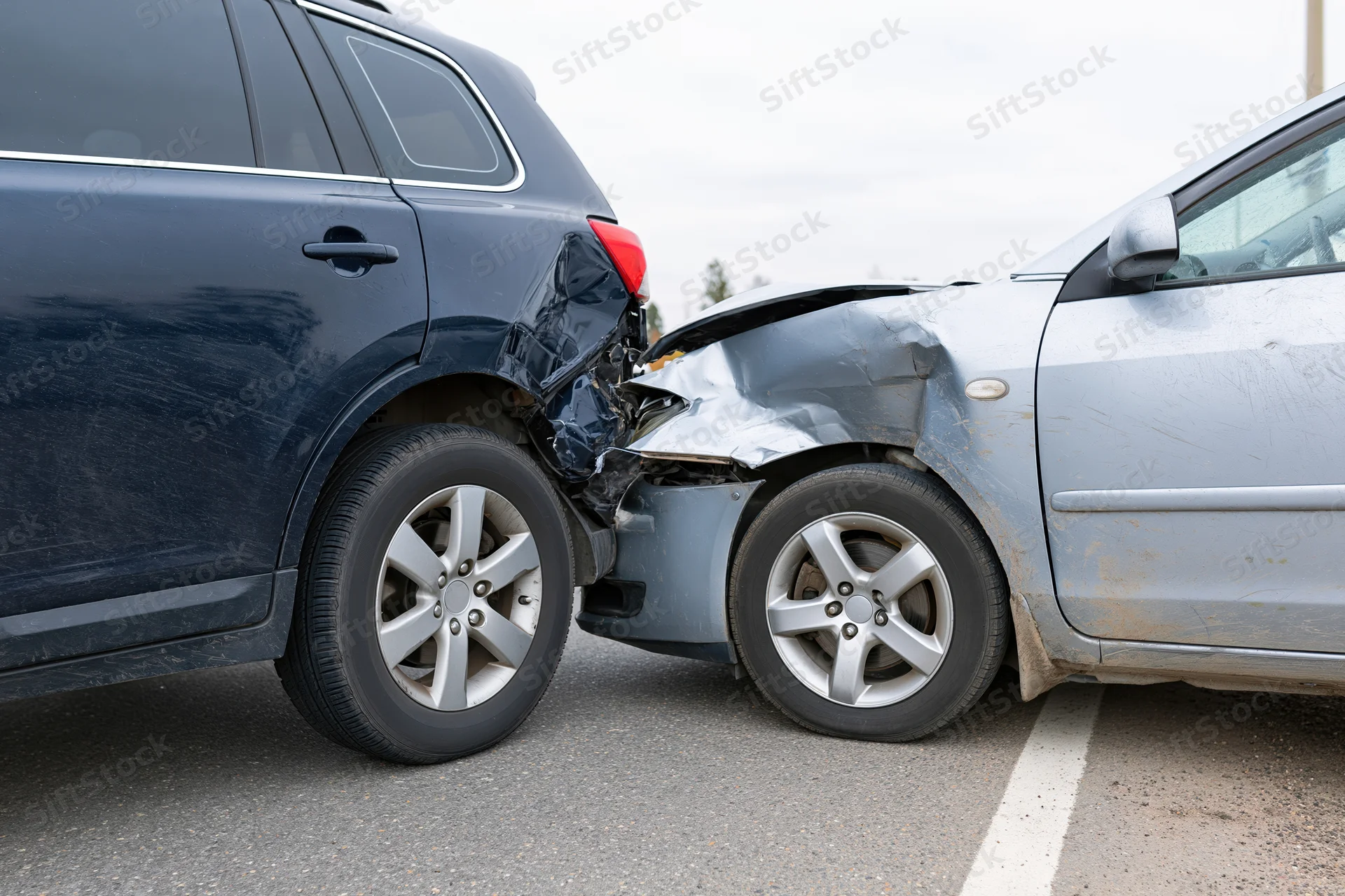Two damaged cars in rear-end collision on asphalt road