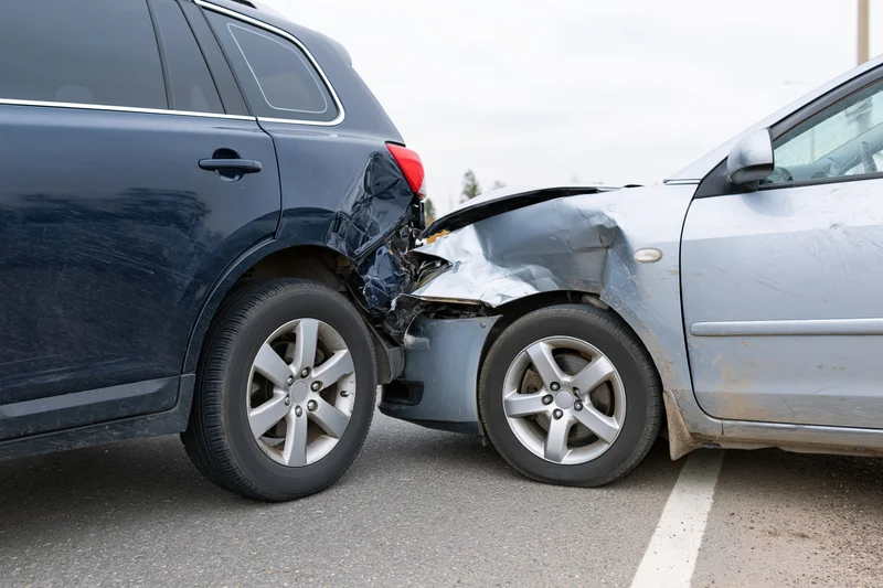 Two damaged cars in rear-end collision on asphalt road