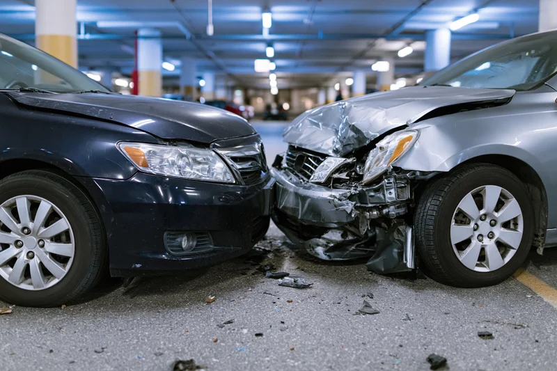 Two damaged cars collided front-to-front in an underground parking garage