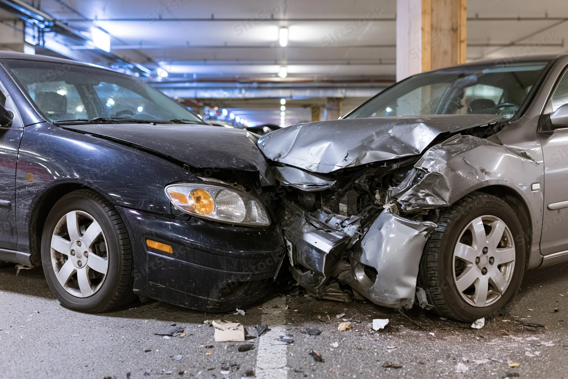 Two damaged cars collided front-end in underground parking garage