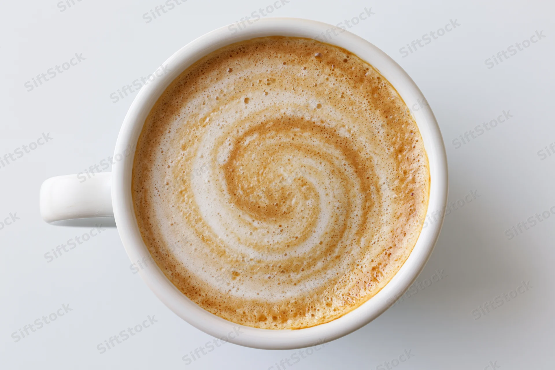 White ceramic coffee cup filled with latte foam swirl viewed from directly above on plain surface