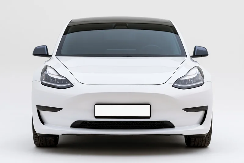 White modern electric sedan viewed straight-on from front in studio setting