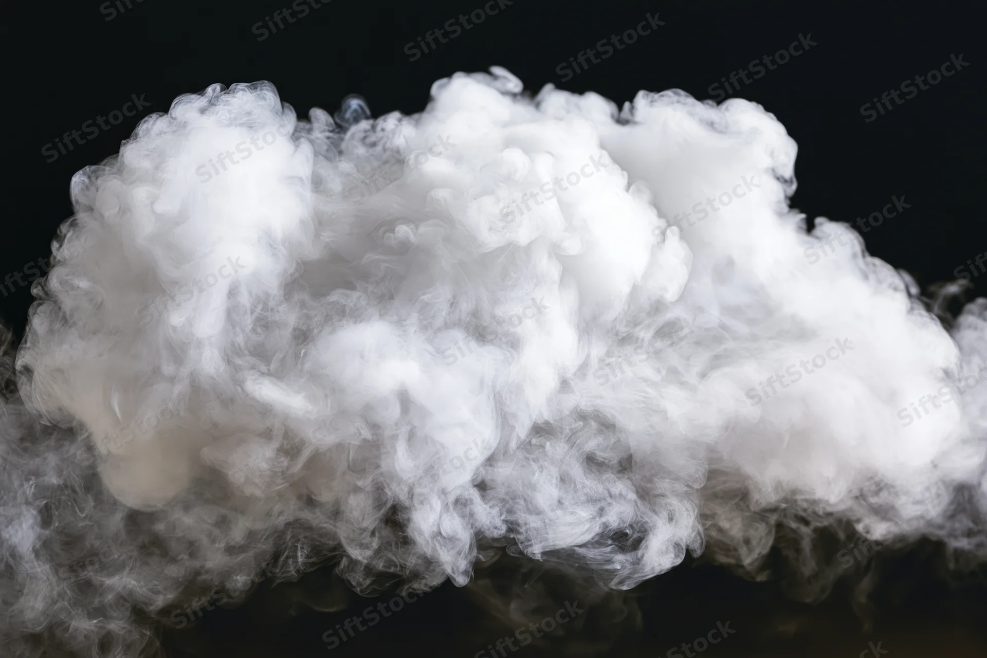 White smoke cloud drifting and dispersing midair against black background